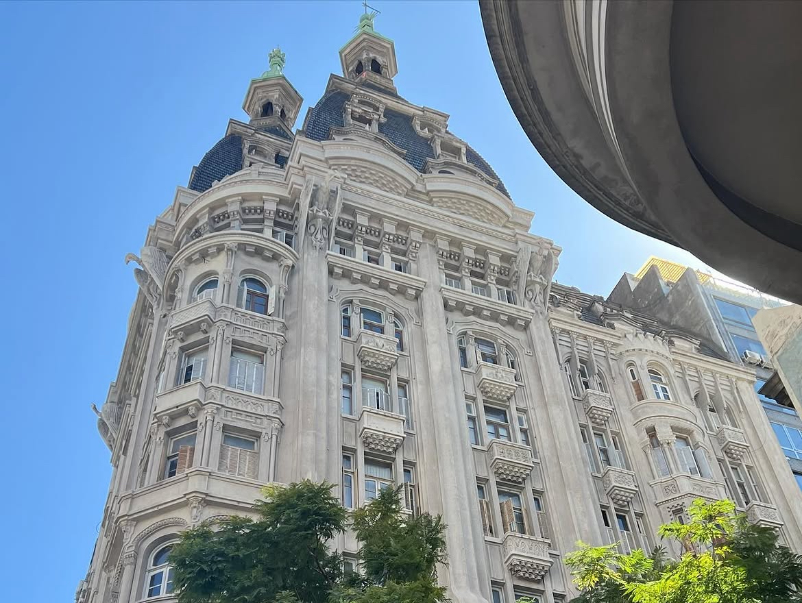 The Otto Wolf building seen from the street corner, its twin towers rising above the roofline