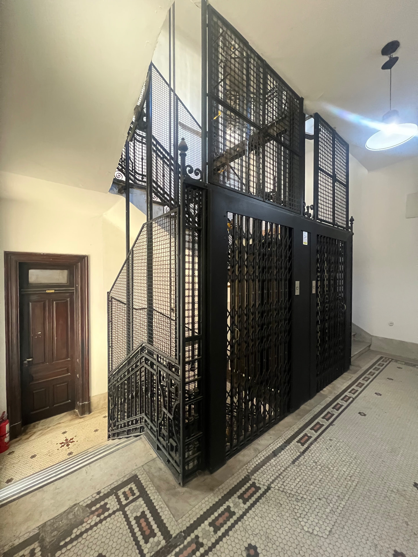 The old caged lift in the stairwell of the building